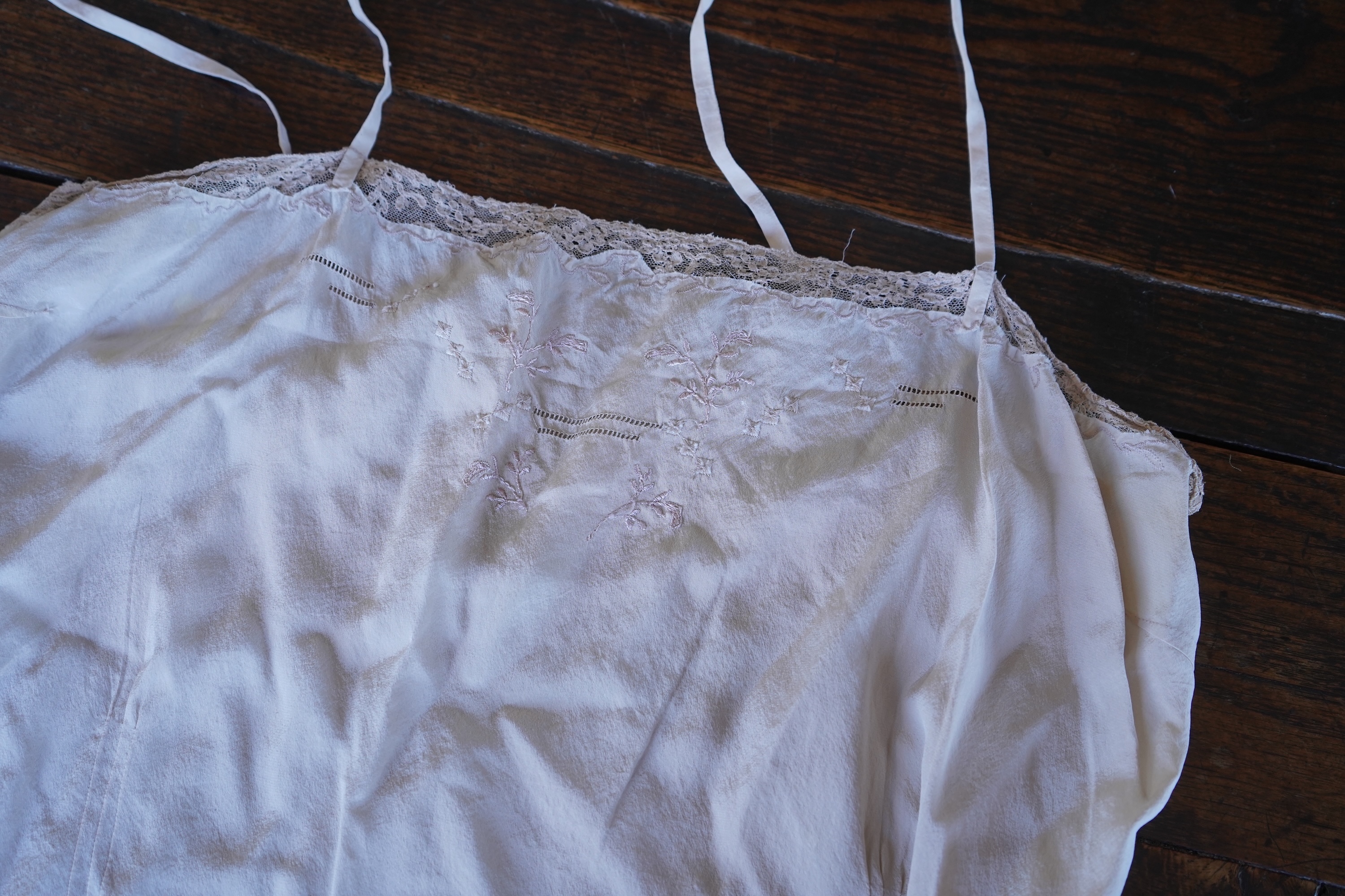 A collection of 1920's-30's silk and satin camisole slips, two cream silk and lace jackets, a lace blouse a silk embroidered blouse, a silk cami, and a collection of silk stockings., Condition- good
